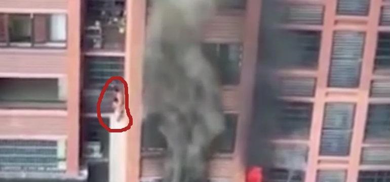 Baja de edificio incendiándose con niño en su espalda (VIDEO)